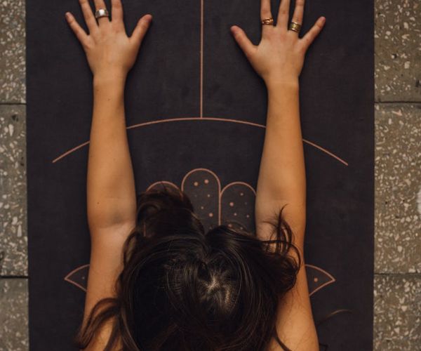 Person meditating peacefully on a yoga mat.